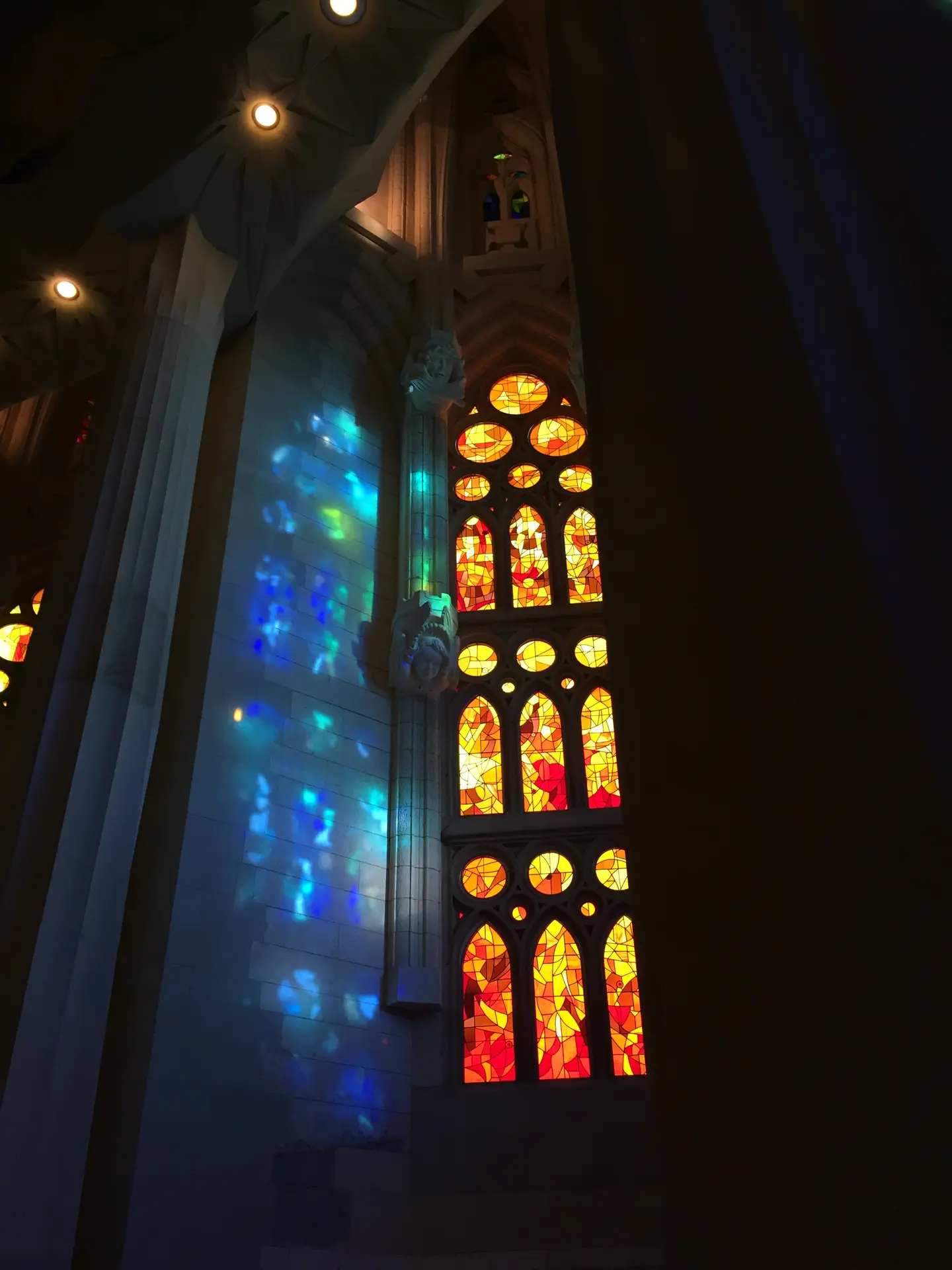 身廊 暖色ステンドグラスの光が柱越しに投影される様子